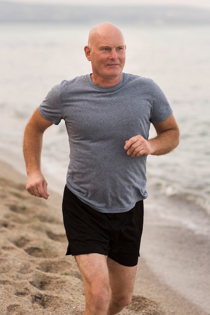 Hombre de tiro medio corriendo en la playa