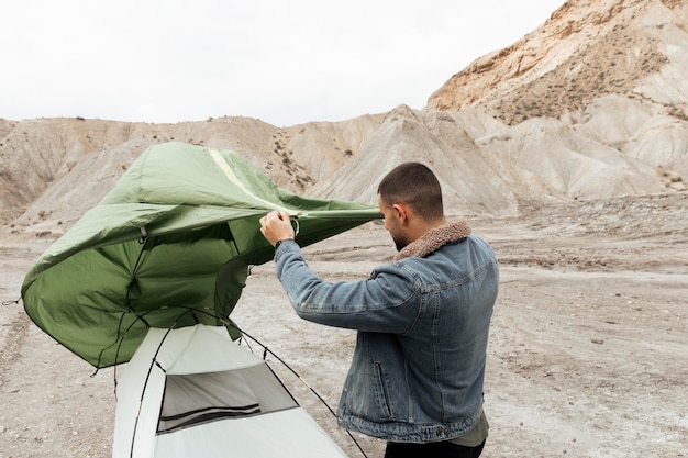 Foto hombre de tiro medio montando una carpa