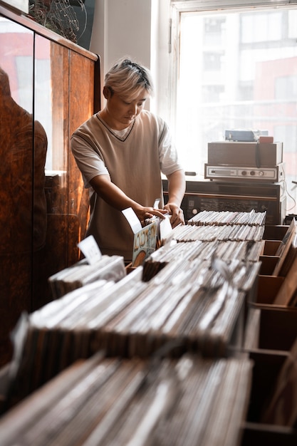 Foto hombre de tiro medio revisando discos de vinilo