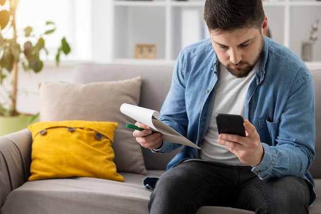 Foto hombre de tiro medio con teléfono inteligente