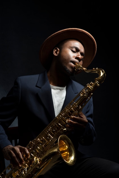 Foto hombre de tiro medio tocando el saxofón