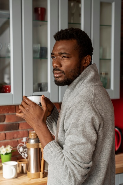 Hombre de tiro medio tomando café en el interior