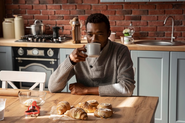 Hombre de tiro medio tomando café