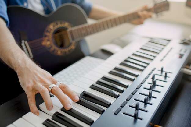 El hombre toca la guitarra y produce una banda sonora electrónica