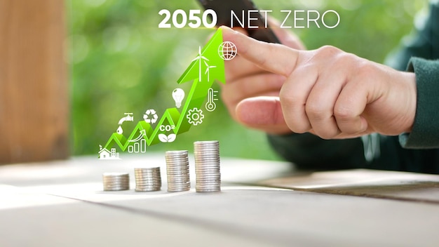 Un hombre toca una pila de monedas con las palabras 2030 net zero en la parte superior
