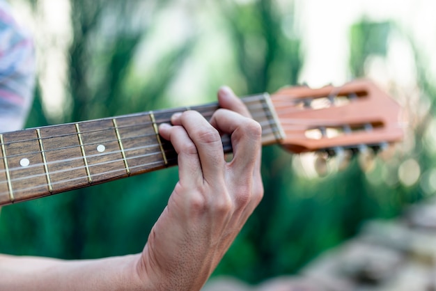 Hombre tocando la guitarra acústica al aire libre