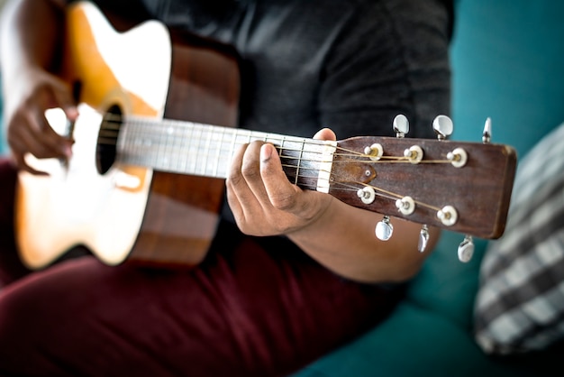 Foto hombre tocando una guitarra acústica