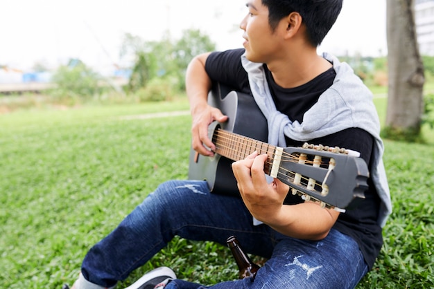 Hombre tocando la guitarra al aire libre