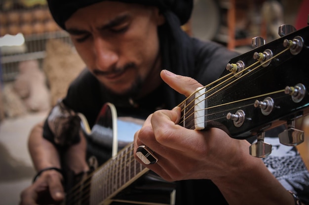 Foto hombre tocando la guitarra en casa