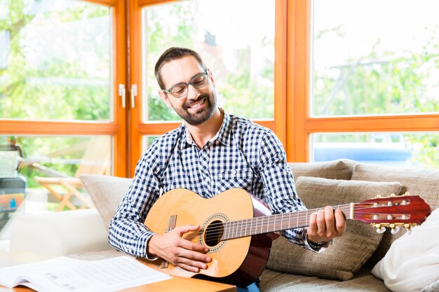 Hombre tocando la guitarra en casa