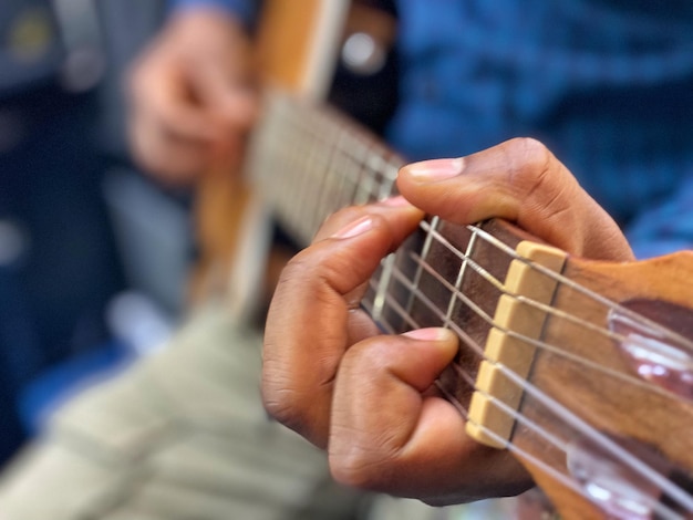 Un hombre tocando una guitarra con los dedos en las cuerdas.