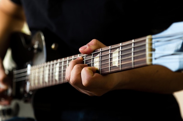 Hombre tocando la guitarra eléctrica negra