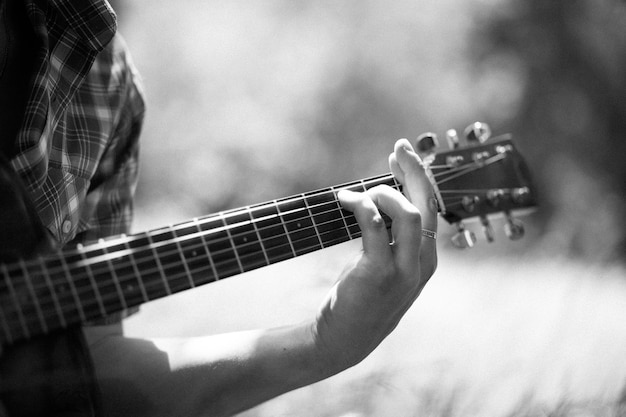 Hombre tocando la guitarra en un picnic. Monocromo.