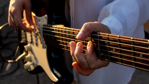 Un hombre tocando una melodía en una guitarra. De cerca