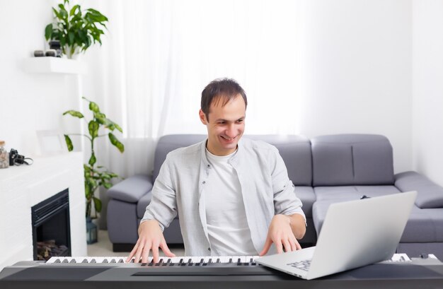 Hombre tocando música con piano y portátil