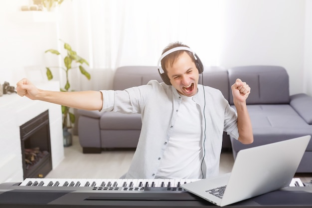 Hombre tocando música con piano y portátil