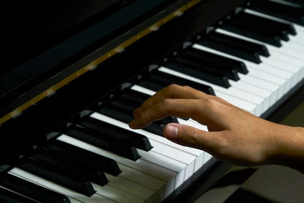 Hombre tocando el piano en el estudio con la mano borrosa