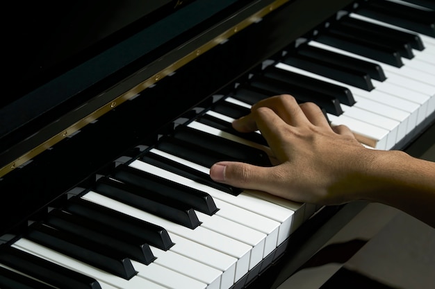 Hombre tocando el piano en el estudio con la mano borrosa