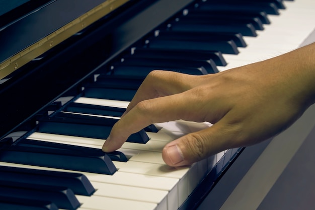 Hombre tocando el piano en el estudio con la mano borrosa