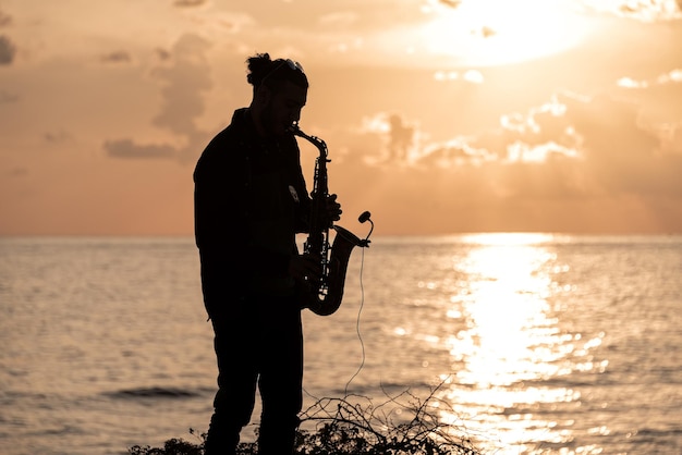 Hombre tocando el saxofón al atardecer