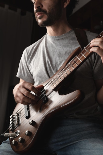 Hombre tocando solo de instrumento de bajo eléctrico de cuatro cuerdas