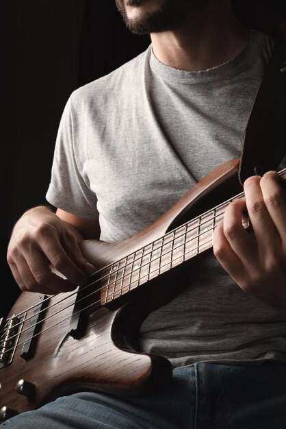 Hombre tocando solo de instrumento de bajo eléctrico de cuatro cuerdas