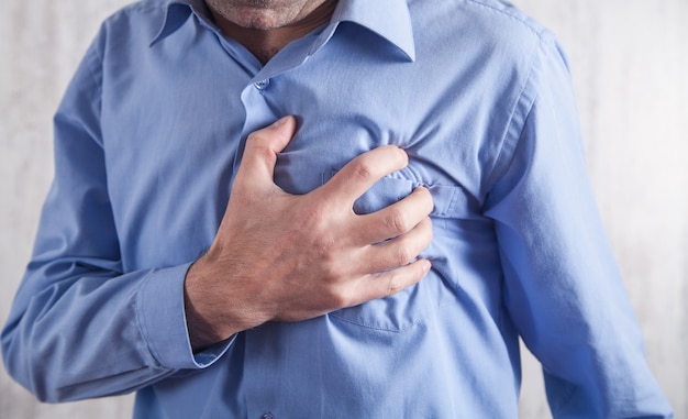 Hombre tocando su corazón. Infarto de miocardio. Enfermedad