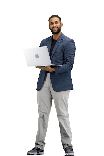 Un hombre de toda la longitud en un fondo blanco usa una computadora portátil