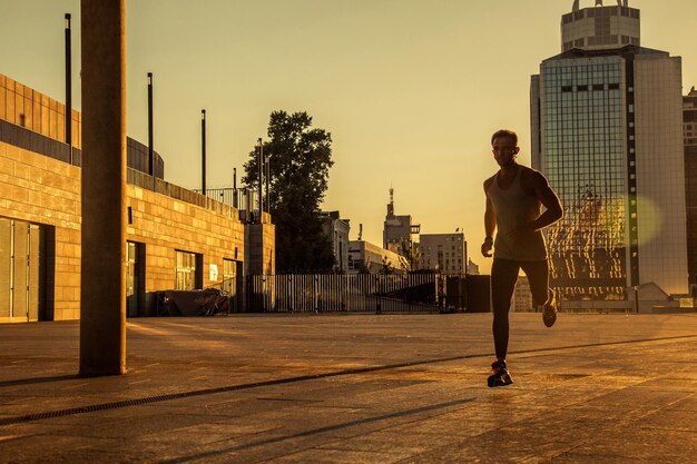 Foto el hombre de toda la longitud de pie en la calle contra los edificios de la ciudad