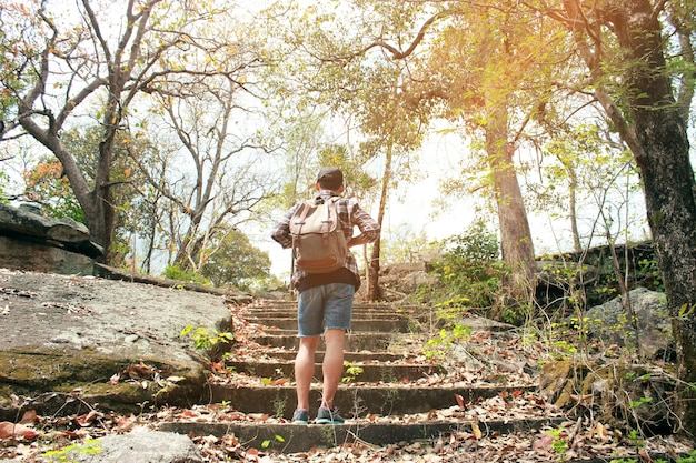 Foto hombre de toda la longitud de pie en escalones en el bosque