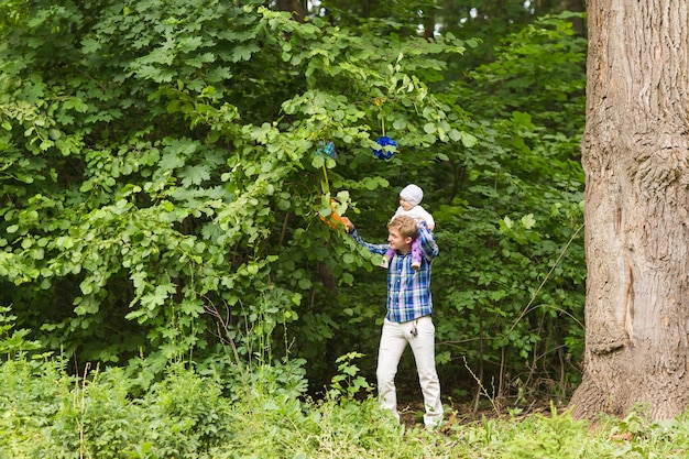 Hombre de toda la longitud de pie junto a un árbol en el bosque.