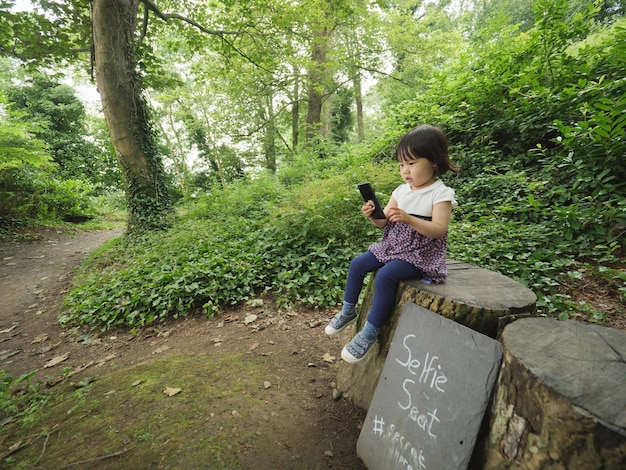 Foto hombre de toda la longitud usando teléfono móvil en el bosque