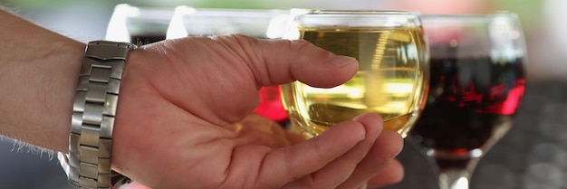 El hombre toma una copa de bebida alcohólica del bar, bebida refrescante, champán o vino.