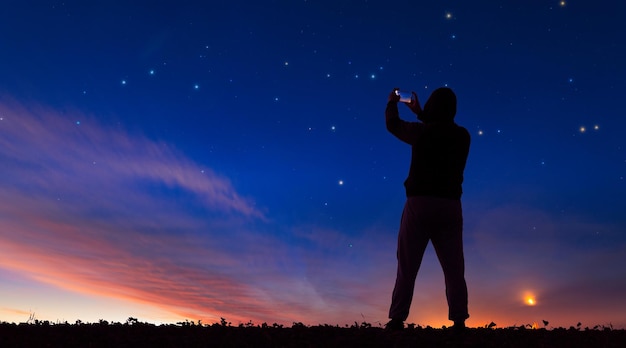 Foto un hombre toma fotos del cielo estrellado en su teléfono