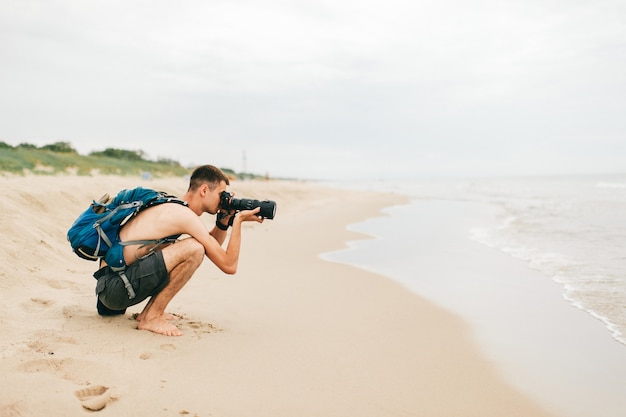 Foto hombre toma fotos en la playa