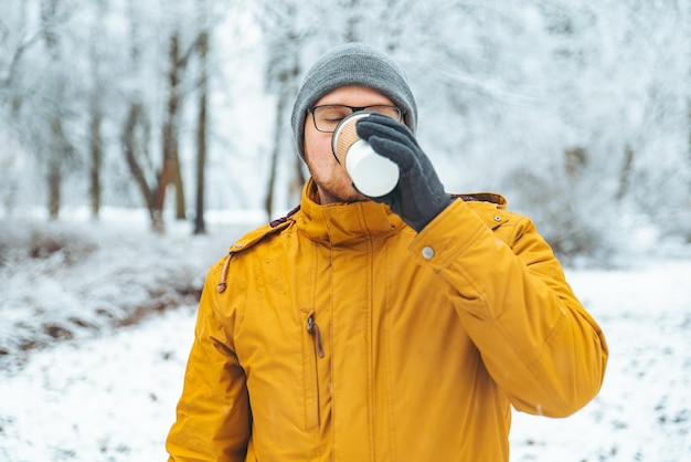 Hombre tomando café en el parque de la ciudad. estilo de vida. casual. invierno nevado