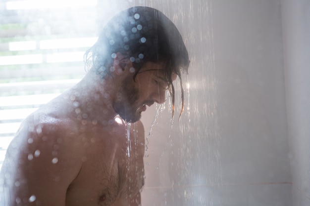 Hombre tomando una ducha en el baño.