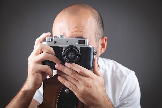 Hombre tomando una foto con una cámara vieja