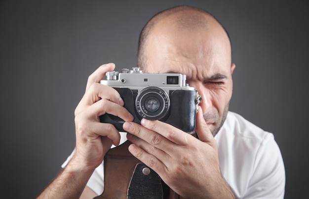 Hombre tomando una foto con una cámara vieja.