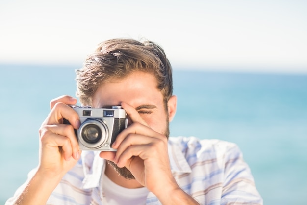 hombre tomando una foto y mirando a cámara