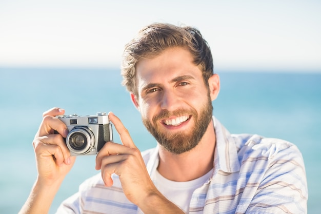 hombre tomando una foto y mirando a cámara