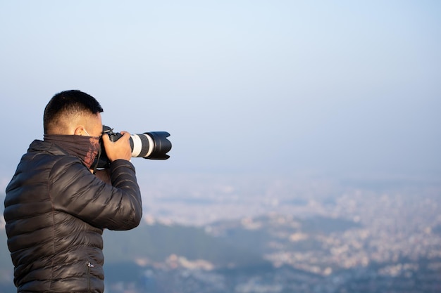 Un hombre tomando una foto de un paisaje urbano con una lente grande en su rostro.