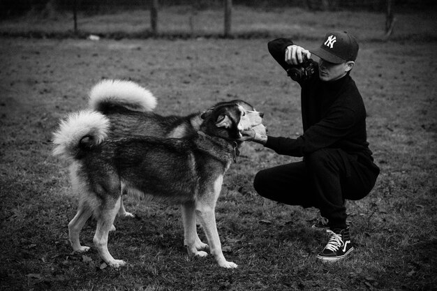 Foto un hombre tomando una foto de un perro y un perro