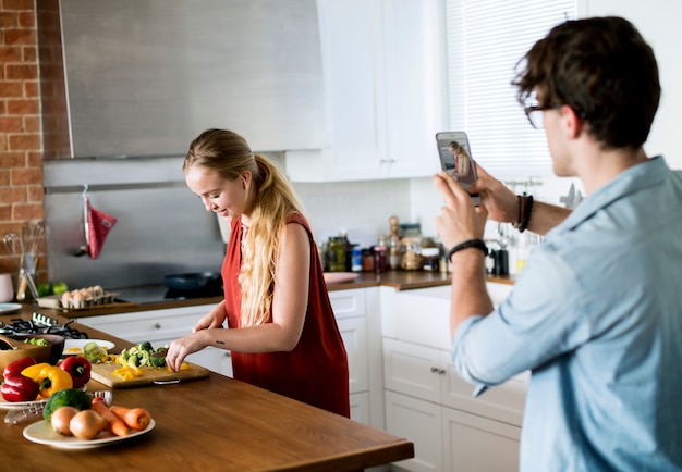 Hombre tomando una foto de su esposa en la cocina.