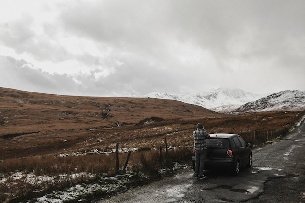 Hombre tomando fotografías de montañas nevadas