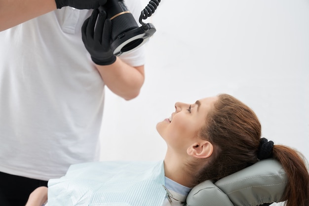 Hombre tomando fotos de dientes después del blanqueamiento en consultorio dental