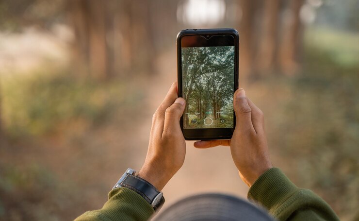 Hombre tomando fotos por teléfono Fotógrafo móvil haciendo clic en la naturaleza