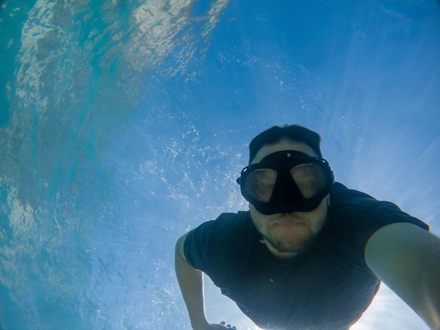 Hombre tomando selfie foto bajo el agua en máscara de buceo verano vacaciones en el mar