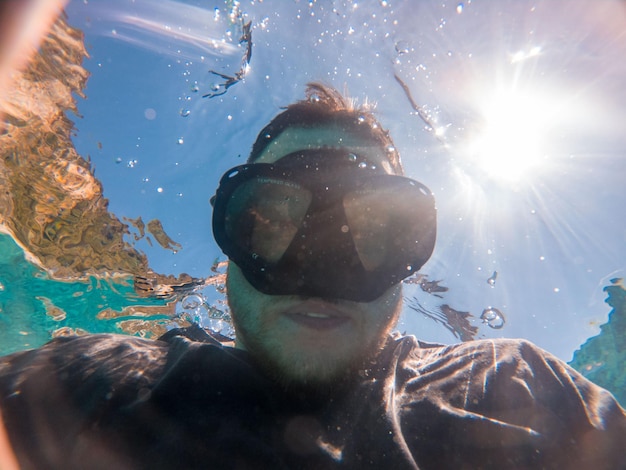 Hombre tomando selfie foto bajo el agua en máscara de buceo verano vacaciones en el mar