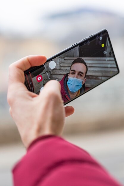 Foto hombre tomando selfie mientras usa máscara médica